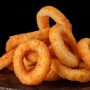 selective focus. fried onion rings in breadcrumbs fried in oil. restaurant serving. on a dark background. for menus and ads. Copy space, menu